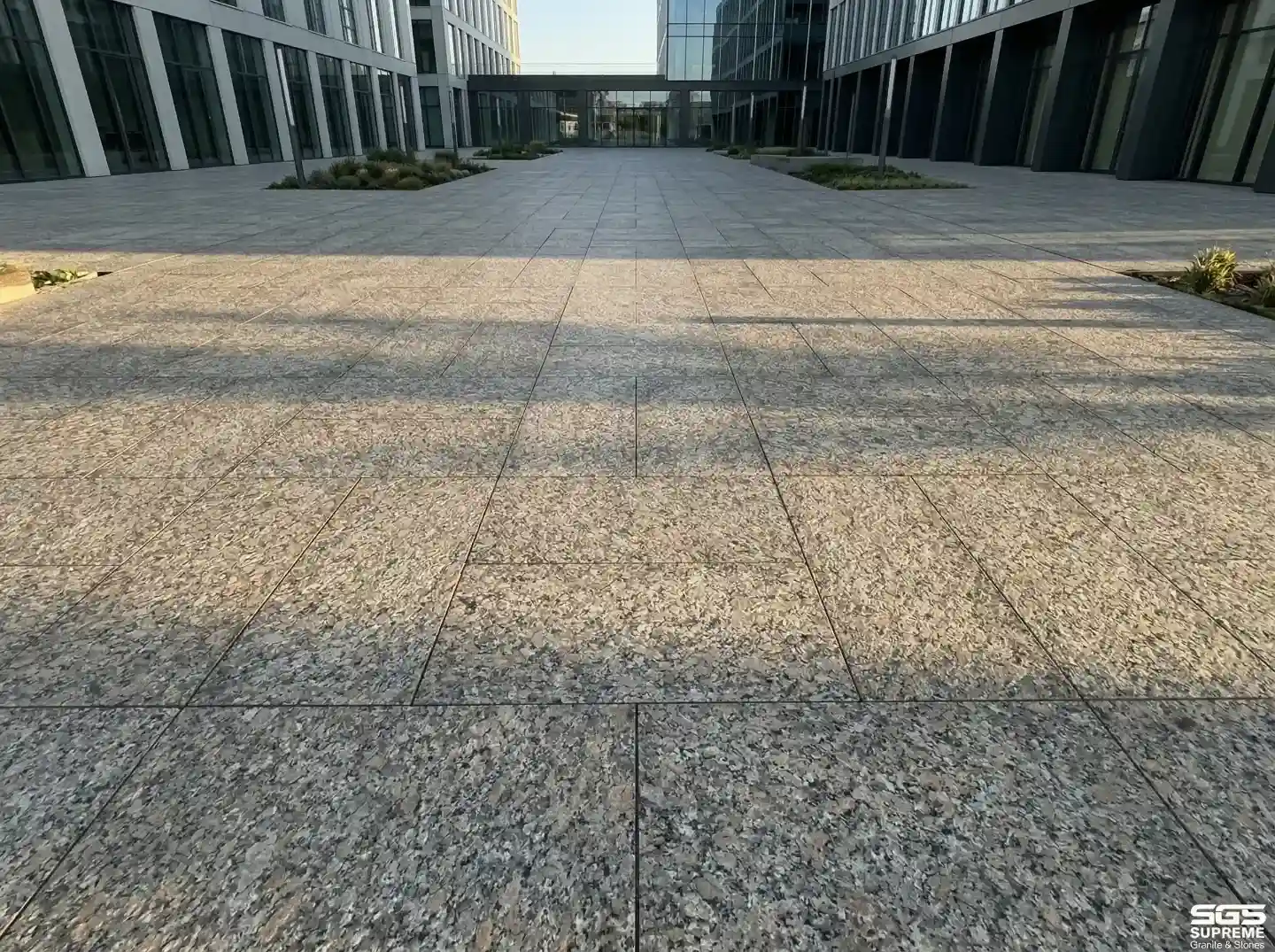 Adunik brown granite used in large commercial plaza flooring with anti-skid finish, durable stone for high-traffic outdoor spaces
