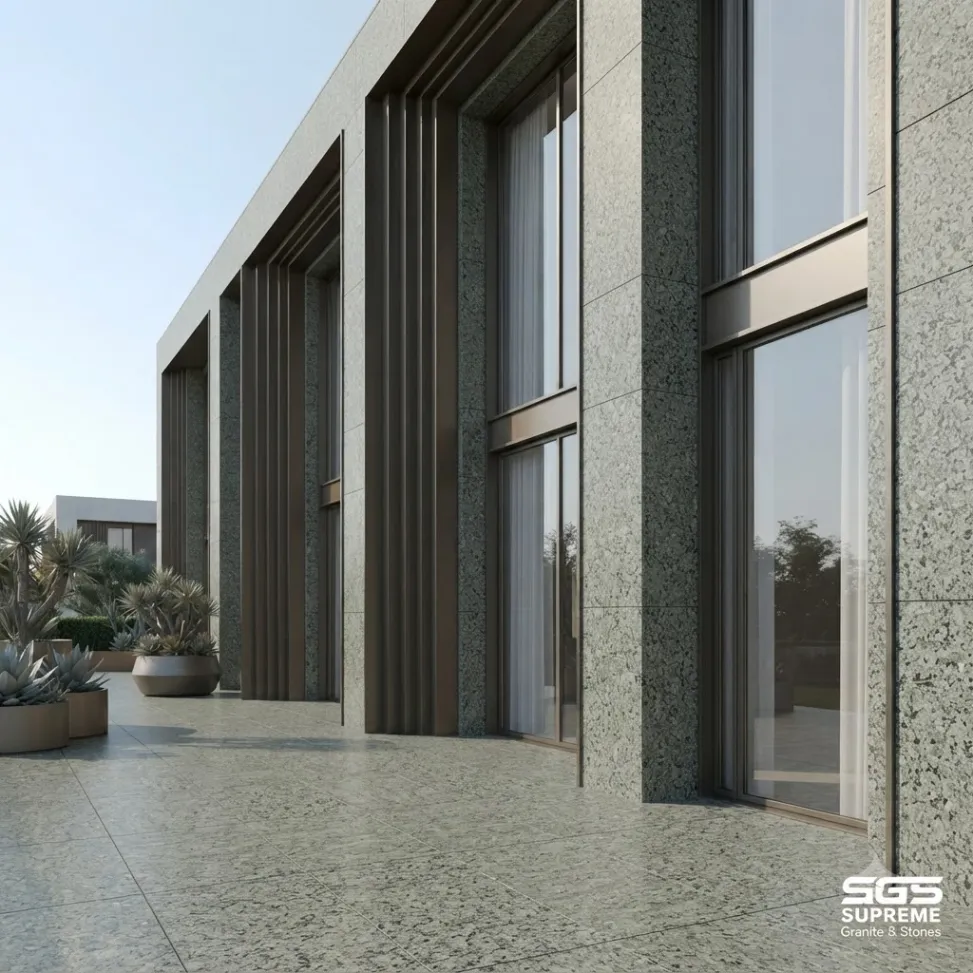 Modern building facade clad in Nousra Green Granite panels around large windows, highlighting its dense green-grey speckled texture for contemporary architectural applications.
