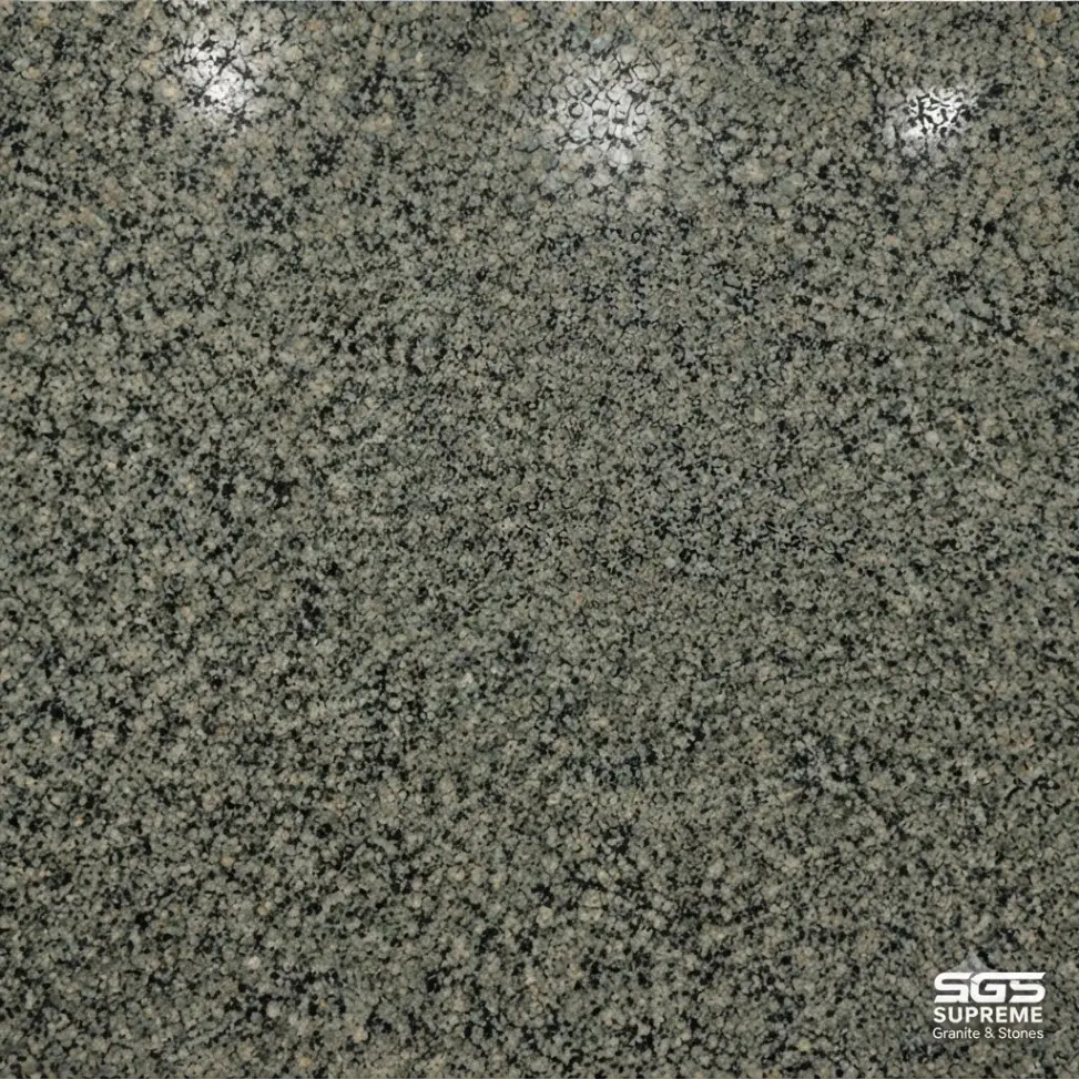 Close-up of Nousra Green Granite showing dense, fine-to-medium mineral grains in green-grey, charcoal black, medium grey, pale grey, and subtle beige tones.