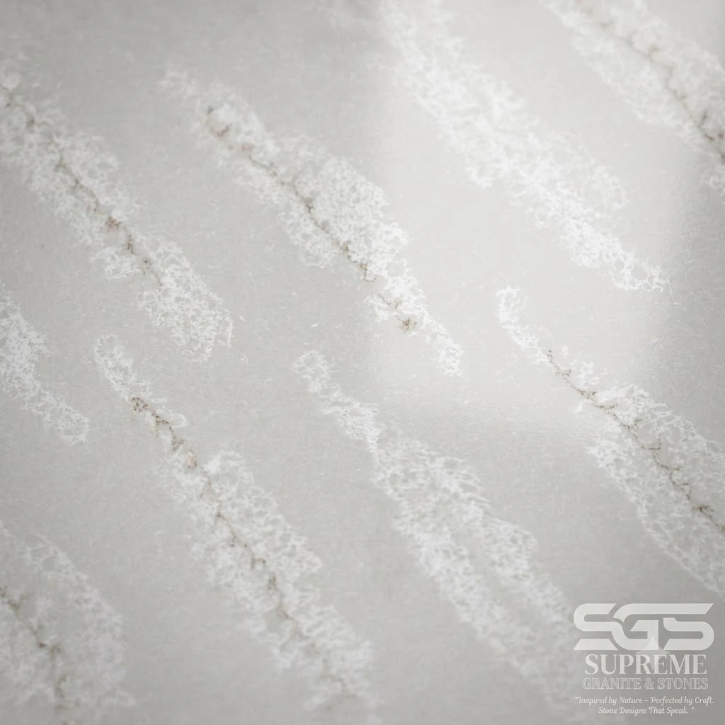 Close-up texture of Simony Quartz showcasing a polished white engineered quartz surface with soft flowing gold and light grey marble-inspired veining, suitable for countertops, vanity tops, wall cladding, and luxury interiors.